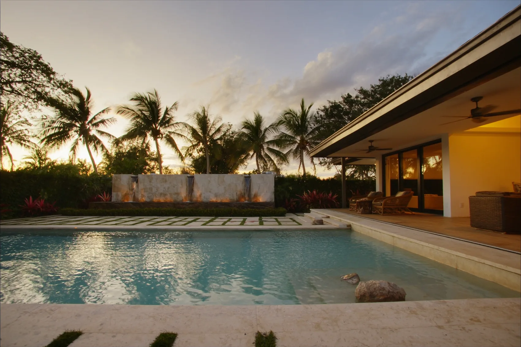 Alberca residencial moderna con cascada de piedra al atardecer en Tampico — AQUATAM